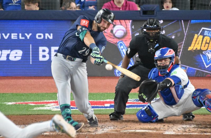 Apr 19, 2025; Toronto, Ontario, CAN;  Seattle Mariners catcher Cal Raleigh (29) hits a double against the Toronto Blue Jays in the fifth inning at Rogers Centre. Mandatory Credit: Dan Hamilton-Imagn Images
