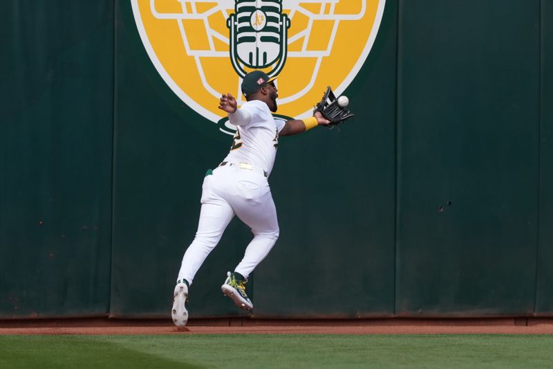 Aug 17, 2024; Oakland, California, USA; Oakland Athletics left fielder Miguel Andujar (22) catches a fly ball against the San Francisco Giants during the first inning at Oakland-Alameda County Coliseum. Mandatory Credit: Darren Yamashita-USA TODAY Sports