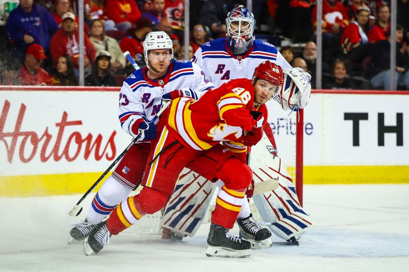 Oct 26, 2025; Calgary, Alberta, CAN; Calgary Flames left wing Joel Farabee (86) and New York Rangers defenseman Adam Fox (23) fights for position in front of New York Rangers goaltender Igor Shesterkin (31) during the second period at Scotiabank Saddledome. Mandatory Credit: Sergei Belski-Imagn Images