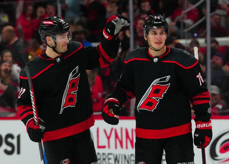 Dec 2, 2023; Raleigh, North Carolina, USA; Carolina Hurricanes defenseman Brady Skjei (76) is congratulated by defenseman Brett Pesce (22) after his goal against the Buffalo Sabres during the third period at PNC Arena. Mandatory Credit: James Guillory-USA TODAY Sports