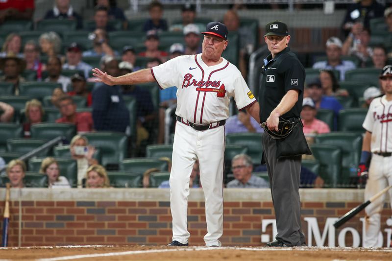 Aug 7, 2024; Atlanta, Georgia, USA; Atlanta Braves manager Brian Snitker (43) reacts to umpire Brian Walsh (120) after being ejected from a game against the Milwaukee Brewers in the fifth inning at Truist Park. Mandatory Credit: Brett Davis-USA TODAY Sports
