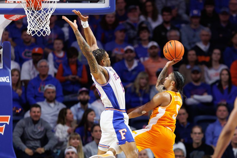 Jan 7, 2025; Gainesville, Florida, USA; Tennessee Volunteers guard Zakai Zeigler (5) attempts a layup over Florida Gators guard Alijah Martin (15) during the second half at Exactech Arena at the Stephen C. O'Connell Center. Mandatory Credit: Matt Pendleton-Imagn Images