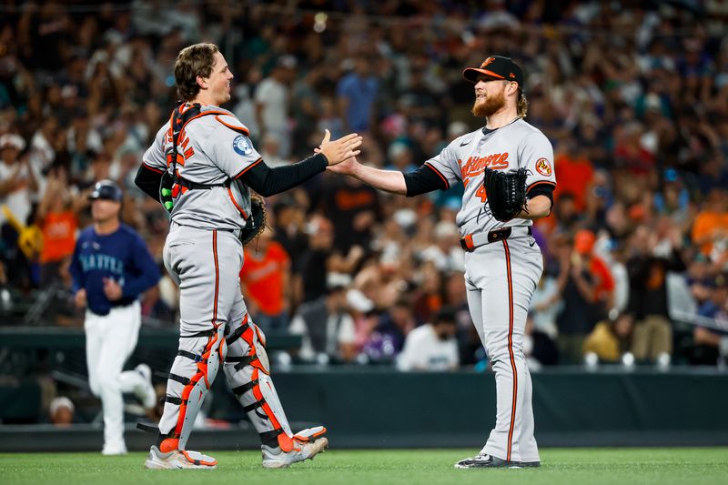 Jul 3, 2024; Seattle, Washington, USA; Baltimore Orioles relief pitcher Craig Kimbrel (46) shakes hands with catcher Adley Rutschman (35) following a 4-1 victory against the Seattle Mariners at T-Mobile Park. Mandatory Credit: Joe Nicholson-USA TODAY Sports