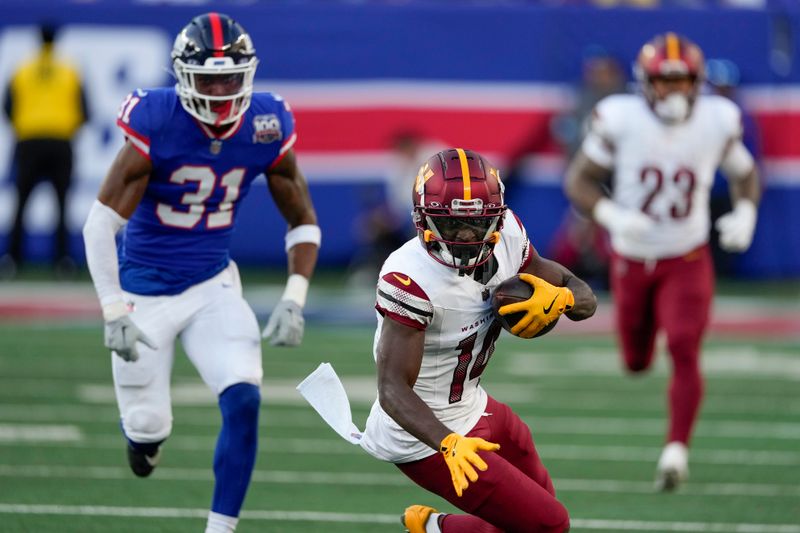 Washington Commanders wide receiver Olamide Zaccheaus (14) carries the ball against the New York Giants during the second half of an NFL football game, Sunday, Nov. 3, 2024, in East Rutherford, N.J. (AP Photo/Seth Wenig)