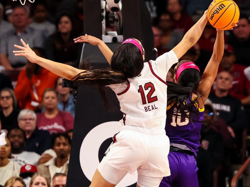 Feb 12, 2023; Columbia, South Carolina, USA; South Carolina Gamecocks guard Brea Beal (12) blocks the shot of LSU Lady Tigers forward Angel Reese (10) in the first half at Colonial Life Arena. Mandatory Credit: Jeff Blake-USA TODAY Sports