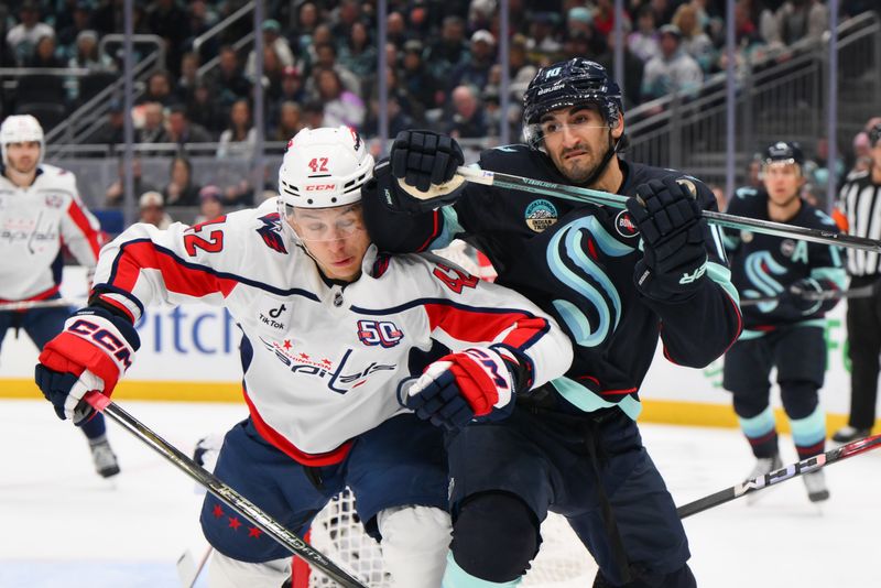 Jan 23, 2025; Seattle, Washington, USA; Washington Capitals defenseman Martin Fehervary (42) is elbowed by Seattle Kraken center Matty Beniers (10) during the first period at Climate Pledge Arena. Mandatory Credit: Steven Bisig-Imagn Images