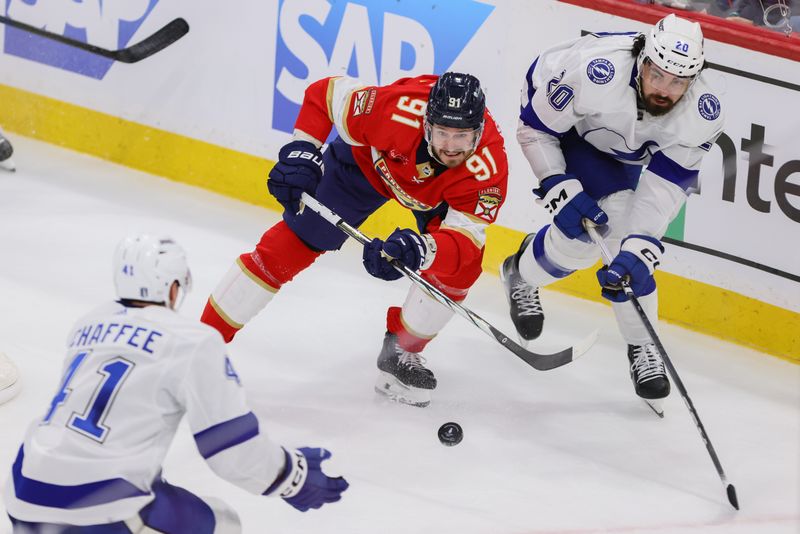 Apr 21, 2024; Sunrise, Florida, USA; Florida Panthers defenseman Oliver Ekman-Larsson (91) moves the puck past Tampa Bay Lightning left wing Nicholas Paul (20) during the third period in game one of the first round of the 2024 Stanley Cup Playoffs at Amerant Bank Arena. Mandatory Credit: Sam Navarro-USA TODAY Sports