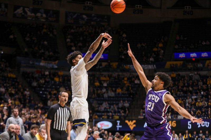 Feb 25, 2025; Morgantown, West Virginia, USA; West Virginia Mountaineers guard Jonathan Powell (11) shoots a three pointer over TCU Horned Frogs guard Noah Reynolds (21) during the first half at WVU Coliseum. Mandatory Credit: Ben Queen-Imagn Images