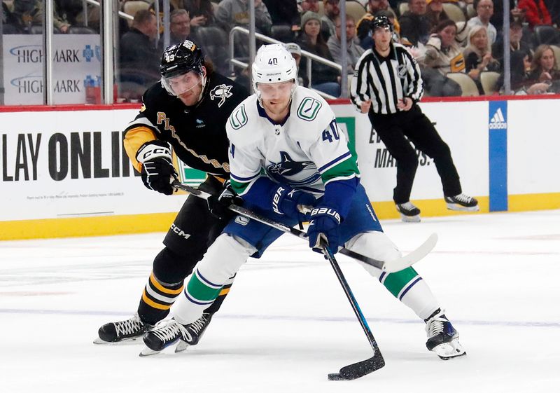 Jan 11, 2024; Pittsburgh, Pennsylvania, USA; Vancouver Canucks center Elias Pettersson (40) skates with the puck against pressure from Pittsburgh Penguins center Jansen Harkins (43) during the second period at PPG Paints Arena.The Canucks won 4-3 in overtime.  Mandatory Credit: Charles LeClaire-USA TODAY Sports