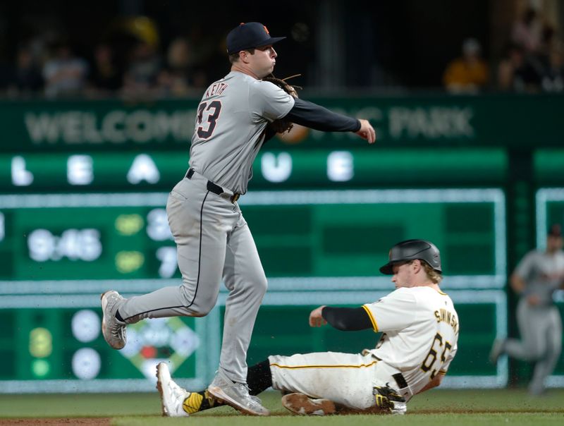 Apr 8, 2024; Pittsburgh, Pennsylvania, USA;  Detroit Tigers second baseman Colt Keith (33) turns a double play over Pittsburgh Pirates center fielder Jack Suwinski (65) to end the sixth inning at PNC Park. Mandatory Credit: Charles LeClaire-USA TODAY Sports