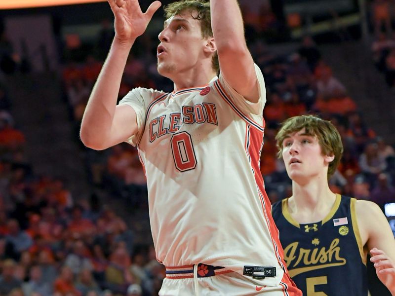 Feb 26, 2025; Clemson, South Carolina, USA; Clemson sophomore center Viktor Lakhin (0) scores near Notre Dame guard Cole Certa (5) during the second half at Littlejohn Coliseum. Mandatory Credit: Ken Ruinard-Imagn Images