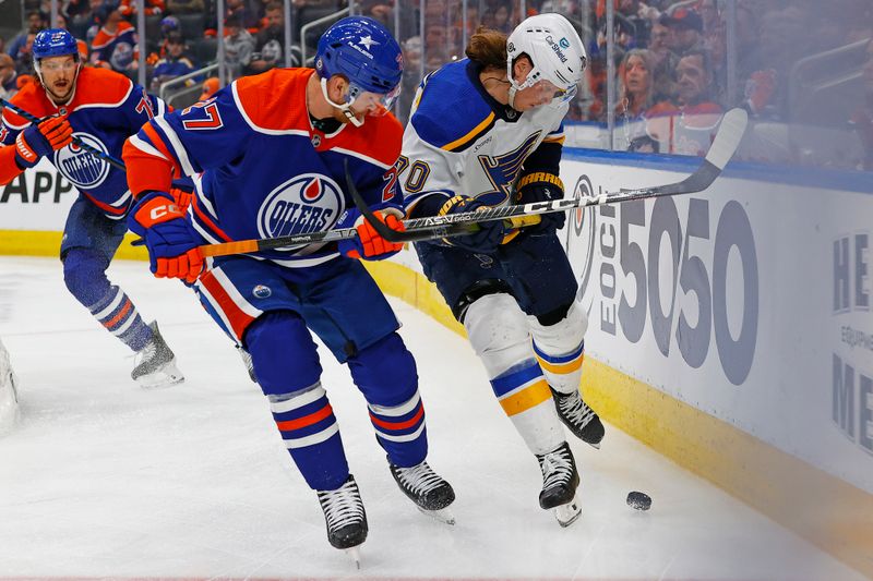 Feb 28, 2024; Edmonton, Alberta, CAN; Edmonton Oilers defensemen Brett Kulak (27)  and St. Louis Blues forward Oskar Sundqvist (70) Battle along the boards for a loose puck  during the second period at Rogers Place. Mandatory Credit: Perry Nelson-USA TODAY Sports