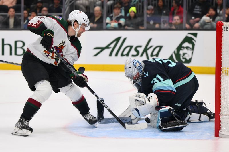 Apr 9, 2024; Seattle, Washington, USA; Seattle Kraken goaltender Philipp Grubauer (31) blocks a goal shot by Arizona Coyotes left wing Matias Maccelli (63) during the first period at Climate Pledge Arena. Mandatory Credit: Steven Bisig-USA TODAY Sports