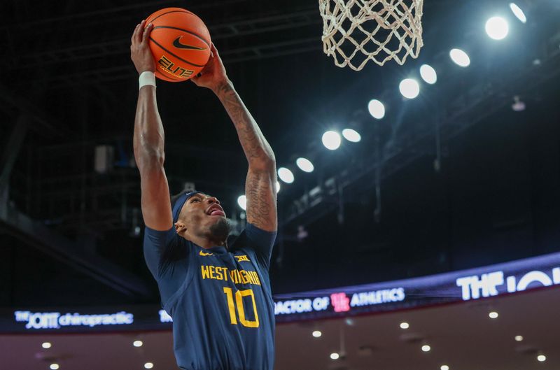 Jan 15, 2025; Houston, Texas, USA;  West Virginia Mountaineers guard Sencire Harris (10) dunks against the Houston Cougars in the first half at Fertitta Center. Mandatory Credit: Thomas Shea-Imagn Images