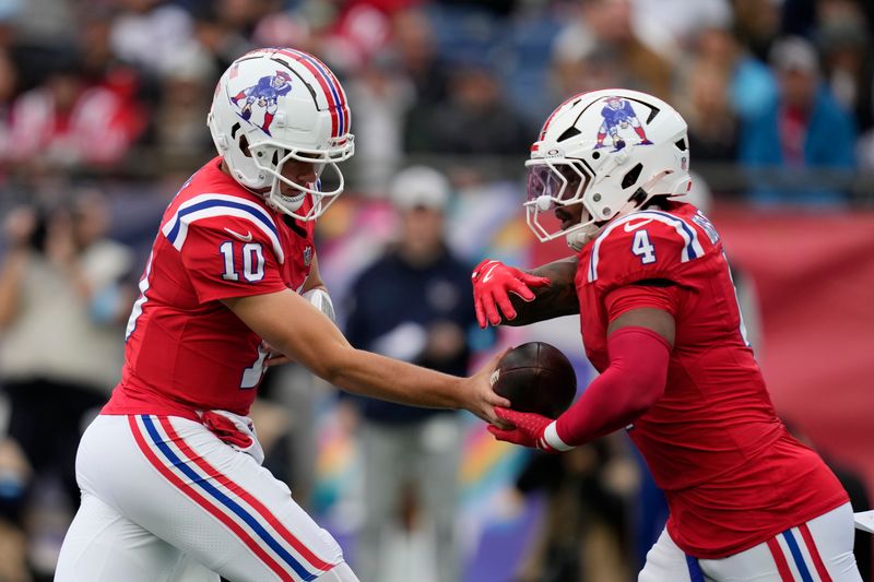 New England Patriots quarterback Drake Maye (10) hands off to running back Antonio Gibson (4) during the first half of an NFL football game against the Houston Texans, Sunday, Oct. 13, 2024, in Foxborough, Mass. (AP Photo/Charles Krupa)