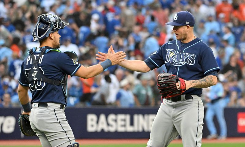 Sep 30, 2023; Toronto, Ontario, CAN;   Tampa Bay Rays relief pitcher Chris Devenski (right) and catcher Rene Pinto (50) celebrate after a win over the Toronto Blue Jays at Rogers Centre. Mandatory Credit: Dan Hamilton-USA TODAY Sports