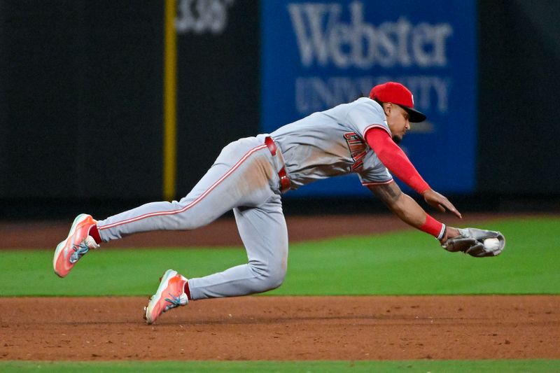 Sep 10, 2024; St. Louis, Missouri, USA;  Cincinnati Reds third baseman Santiago Espinal (4) dives and fields a ground ball against the St. Louis Cardinals during the eighth inning at Busch Stadium. Mandatory Credit: Jeff Curry-Imagn Images