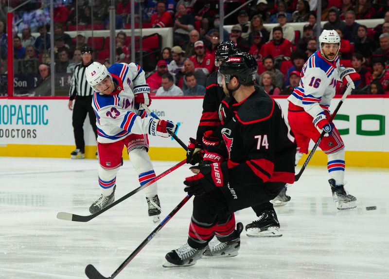 Mar 12, 2024; Raleigh, North Carolina, USA; New York Rangers defenseman Adam Fox (23) takes a shot against the Carolina Hurricanes during the second period at PNC Arena. Mandatory Credit: James Guillory-USA TODAY Sports