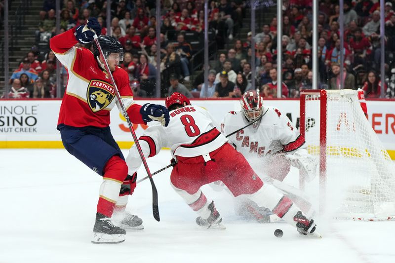 Nov 10, 2023; Sunrise, Florida, USA; Carolina Hurricanes defenseman Brent Burns (8) knocks the puck away from Florida Panthers center Steven Lorentz (18) during the second period at Amerant Bank Arena. Mandatory Credit: Jasen Vinlove-USA TODAY Sports