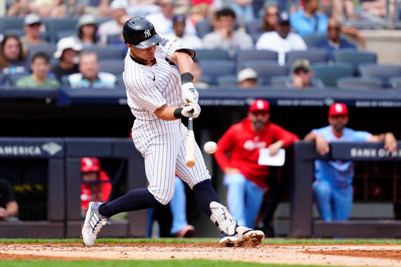 Aug 31, 2024; Bronx, New York, USA; New York Yankees shortstop Anthony Volpe (11) hits an RBI single against the St. Louis Cardinals during the second inning at Yankee Stadium. Mandatory Credit: Gregory Fisher-USA TODAY Sports