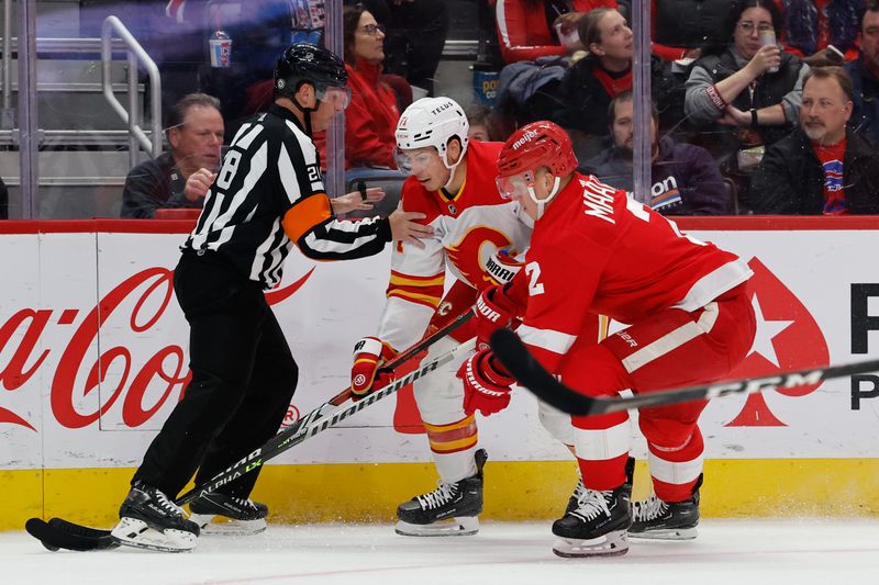 Oct 22, 2023; Detroit, Michigan, USA;  Calgary Flames center Walker Duehr (71) and Detroit Red Wings defenseman Olli Maatta (2) battle for the puck in the first period at Little Caesars Arena. Mandatory Credit: Rick Osentoski-USA TODAY Sports