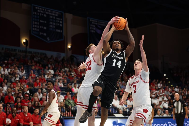 Nov 27, 2025; San Diego, CA, USA; Providence Friars guard Jr. Corey Floyd (14) is fouled by Wisconsin Badgers forward Austin Rapp (22) during the first half at Jenny Craig Pavilion. Mandatory Credit: Abe Arredondo-Imagn Images