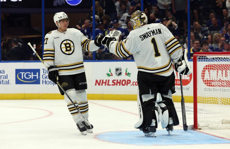 Nov 20, 2023; Tampa, Florida, USA; Boston Bruins defenseman Hampus Lindholm (27) and Boston Bruins goaltender Jeremy Swayman (1) celebrate after they scored against the Tampa Bay Lightning during the third period at Amalie Arena. Mandatory Credit: Kim Klement Neitzel-USA TODAY Sports