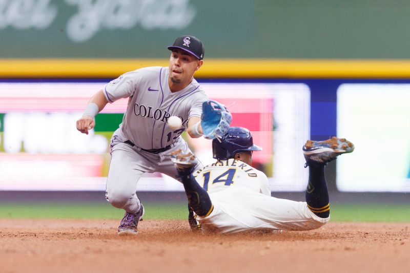 Aug 8, 2023; Milwaukee, Wisconsin, USA;  Milwaukee Brewers second baseman Andruw Monasterio (14) steals second base as Colorado Rockies second baseman Alan Trejo (13) fields the throw during the second inning at American Family Field. Mandatory Credit: Jeff Hanisch-USA TODAY Sports