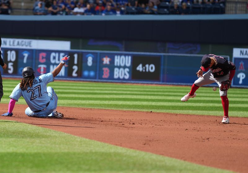 Aug 30, 2023; Toronto, Ontario, CAN; Toronto Blue Jays first baseman Vladimir Guerrero Jr. (27) slides into second base ahead of the tag from Washington Nationals second baseman Ildemaro Vargas (14) during the first inning at Rogers Centre. Mandatory Credit: Nick Turchiaro-USA TODAY Sports