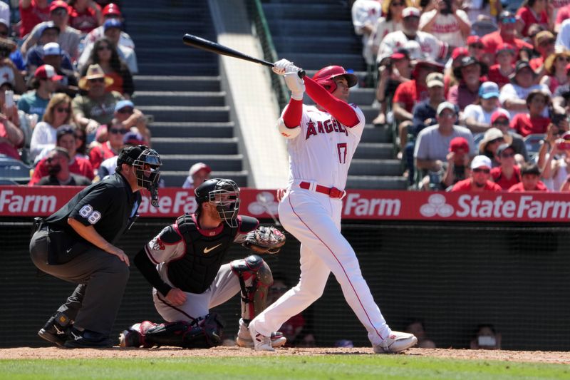 Jul 2, 2023; Anaheim, California, USA; Los Angeles Angels designated hitter Shohei Ohtani (17) hits a solo home run in the eighth inning as Arizona Diamondbacks catcher Carson Kelly (18) and home plate umpire Doug Eddings (88) watch at Angel Stadium. Mandatory Credit: Kirby Lee-USA TODAY Sports