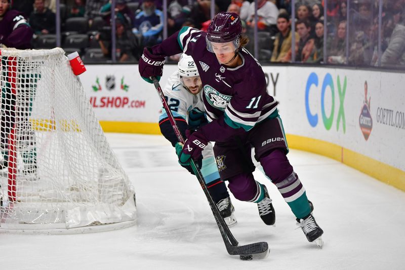 Dec 23, 2023; Anaheim, California, USA; Anaheim Ducks center Trevor Zegras (11) moves the puck ahead of Seattle Kraken right wing Oliver Bjorkstrand (22) during the third period at Honda Center. Mandatory Credit: Gary A. Vasquez-USA TODAY Sports