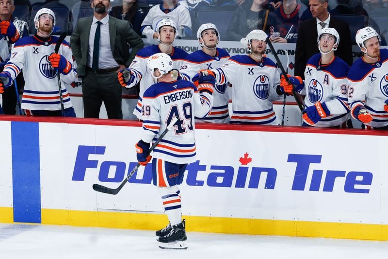 Sep 23, 2025; Winnipeg, Manitoba, CAN;  Edmonton Oilers defenseman Ty Emberson (49) is congratulated by his teammates after scoring against the Winnipeg Jets during the third period at Canada Life Centre. Mandatory Credit: Terrence Lee-Imagn Images