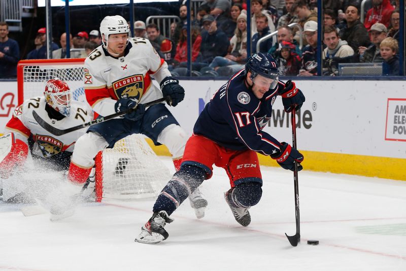 Mar 20, 2025; Columbus, Ohio, USA; Columbus Blue Jackets right wing Justin Danforth (17) skated away from the check of Florida Panthers center Sam Reinhart (13) during the second period at Nationwide Arena. Mandatory Credit: Russell LaBounty-Imagn Images