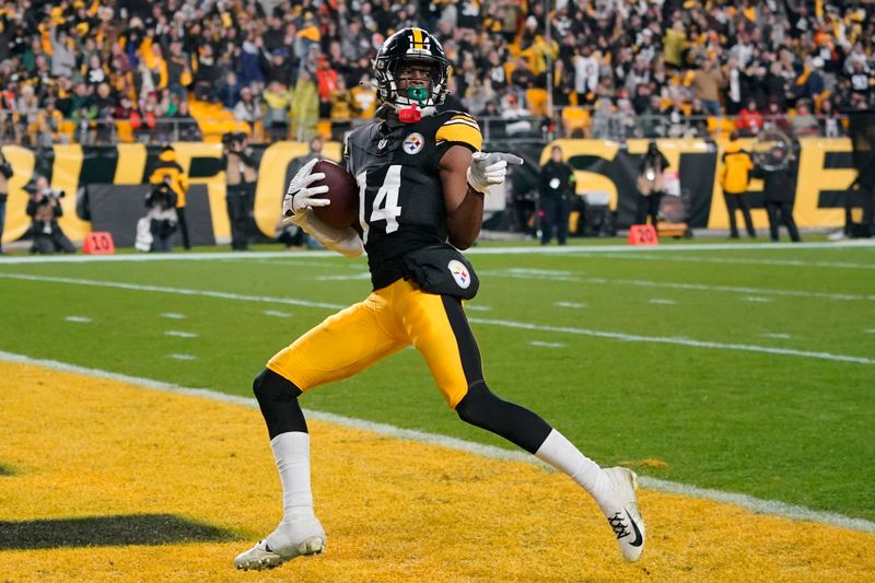 Pittsburgh Steelers wide receiver George Pickens (14) scores on after catching a pass from quarterback Mason Rudolph during an NFL football game against the Cincinnati Bengals in Pittsburgh, Saturday Dec. 23, 2023. (AP Photo/Gene J. Puskar)