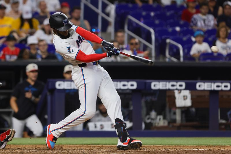 Jul 4, 2024; Miami, Florida, USA; Miami Marlins left fielder Bryan De La Cruz (14) hits an RBI single against the Boston Red Sox during the eighth inning at loanDepot Park. Mandatory Credit: Sam Navarro-USA TODAY Sports