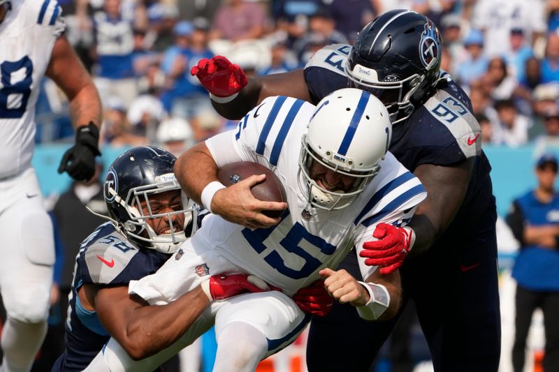 Indianapolis Colts quarterback Joe Flacco (15) is tackled by Tennessee Titans linebacker Harold Landry III, left, and defensive tackle T'Vondre Sweat (93) during the second half of an NFL football game Sunday, Oct. 13, 2024, in Nashville, Tenn. (AP Photo/George Walker IV)