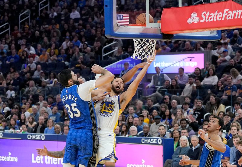 SAN FRANCISCO, CALIFORNIA - JANUARY 02: Stephen Curry #30 of the Golden State Warriors shoots over Goga Bitadze #35 of the Orlando Magic during the third quarter of an NBA basketball game at Chase Center on January 02, 2024 in San Francisco, California. NOTE TO USER: User expressly acknowledges and agrees that, by downloading and or using this photograph, User is consenting to the terms and conditions of the Getty Images License Agreement. (Photo by Thearon W. Henderson/Getty Images)