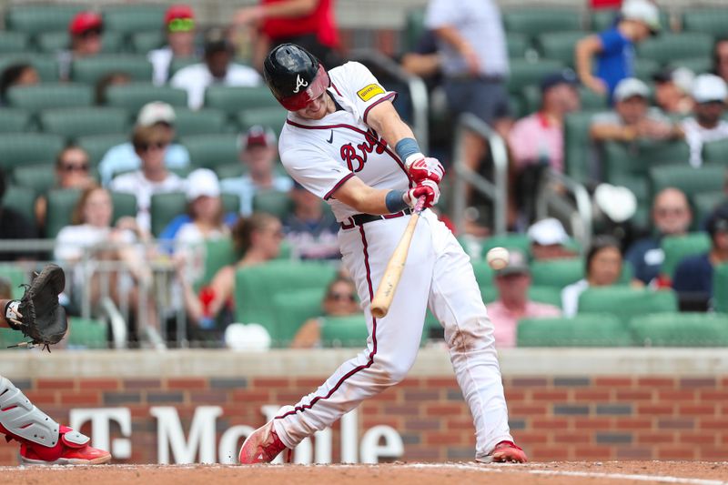 Aug 4, 2024; Cumberland, Georgia, USA; Atlanta Braves catcher Sean Murphy (12) hits a single during a game against the Miami Marlins in the eight inning at Truist Park. Mandatory Credit: Mady Mertens-USA TODAY Sports