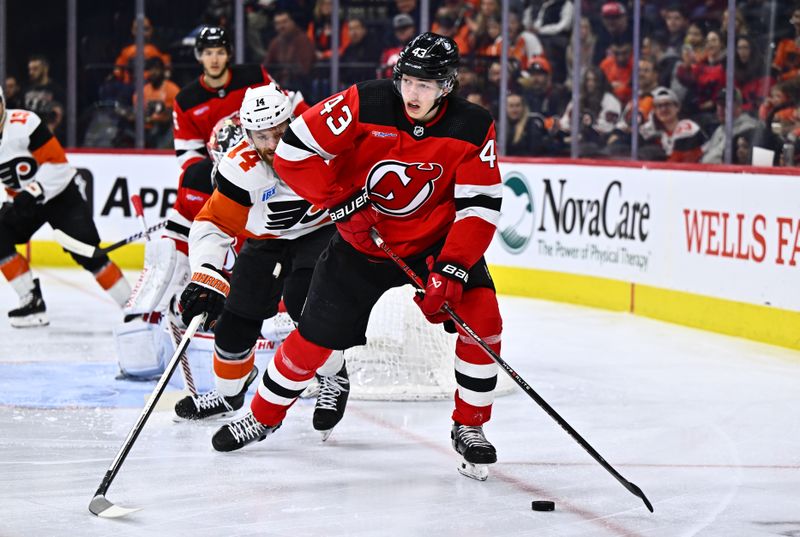 Apr 13, 2024; Philadelphia, Pennsylvania, USA; New Jersey Devils defenseman Luke Hughes (43) controls the puck against Philadelphia Flyers center Sean Couturier (14) in the first period at Wells Fargo Center. Mandatory Credit: Kyle Ross-USA TODAY Sports