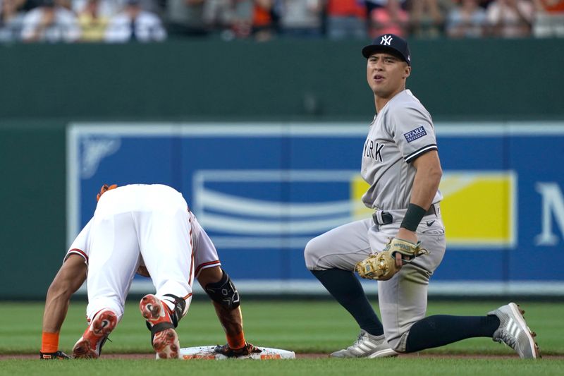 Jul 30, 2023; Baltimore, Maryland, USA; Baltimore Orioles outfielder Anthony Santander (25) rides in with a double to drive in two runs in the first inning defended by New York Yankees shortstop Anthony Volpe (11) at Oriole Park at Camden Yards. Mandatory Credit: Mitch Stringer-USA TODAY Sports