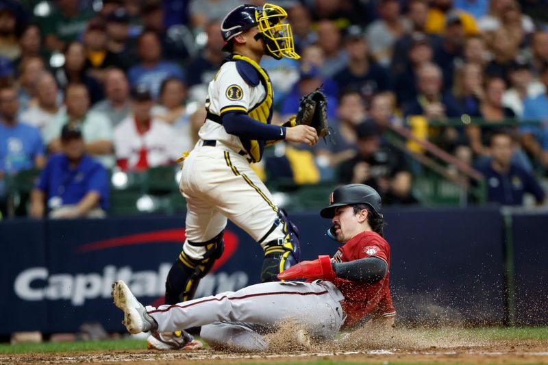 Oct 4, 2023; Milwaukee, Wisconsin, USA; Arizona Diamondbacks left fielder Corbin Carroll (7) slides home to score in the sixth inning against Milwaukee Brewers catcher William Contreras (24) during game two of the Wildcard series for the 2023 MLB playoffs at American Family Field. Mandatory Credit: Kamil Krzaczynski-USA TODAY Sports