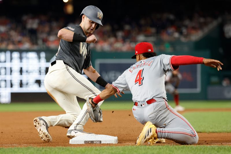 Jul 20, 2024; Washington, District of Columbia, USA; Washington Nationals outfielder Lane Thomas (28) steals third base ahead of a tag by Cincinnati Reds third baseman Santiago Espinal (4) during the seventh inning at Nationals Park. Mandatory Credit: Geoff Burke-USA TODAY Sports