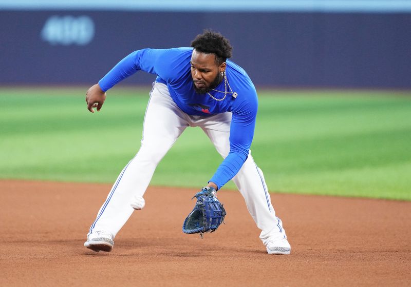 Aug 9, 2024; Toronto, Ontario, CAN; Toronto Blue Jays first baseman Vladimir Guerrero Jr. (27) fields balls during batting practice before a game against the Oakland Athletics at Rogers Centre. Mandatory Credit: Nick Turchiaro-USA TODAY Sports