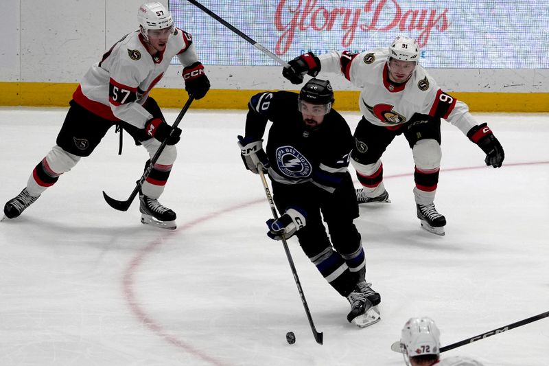 Feb 19, 2024; Tampa, Florida, USA; Tampa Bay Lightning left wing Nicholas Paul (20) moves the puck against Ottawa Senators center Shane Pinto (57) and right wing Vladimir Tarasenko (91) during the first period at Amalie Arena. Mandatory Credit: Dave Nelson-USA TODAY Sports