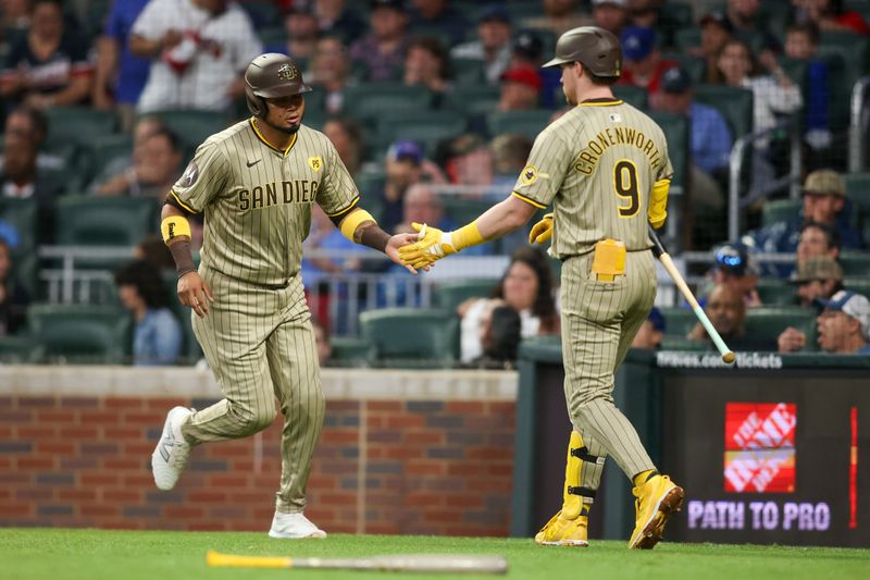 May 17, 2024; Atlanta, Georgia, USA; San Diego Padres second baseman Luis Arraez (4) celebrates after scoring with first baseman Jake Cronenworth (9) against the Atlanta Braves in the fifth inning at Truist Park. Mandatory Credit: Brett Davis-USA TODAY Sports