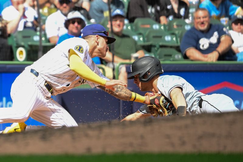 Jun 2, 2024; Milwaukee, Wisconsin, USA;  Milwaukee Brewers third baseman Joey Ortiz (3) tags out Chicago White Sox shortstop Zach Remillard (1) trying to steal third base in the eighth inning at American Family Field. Mandatory Credit: Benny Sieu-USA TODAY Sports