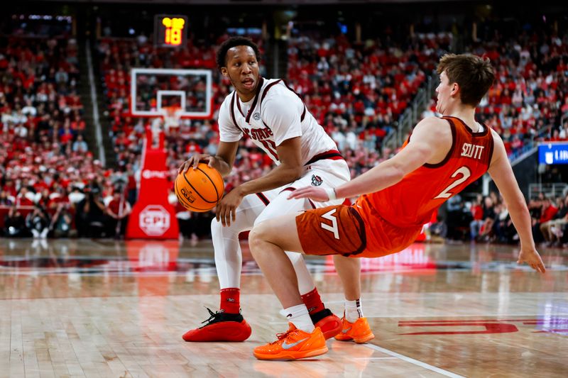 Feb 7, 2026; Raleigh, North Carolina, USA; NC State Wolfpack guard Quadir Copeland (11) with the ball shoves Virginia Tech Hokies guard Jaden Schutt (2) during the first half of the game at Lenovo Center. Mandatory Credit: Jaylynn Nash-Imagn Images