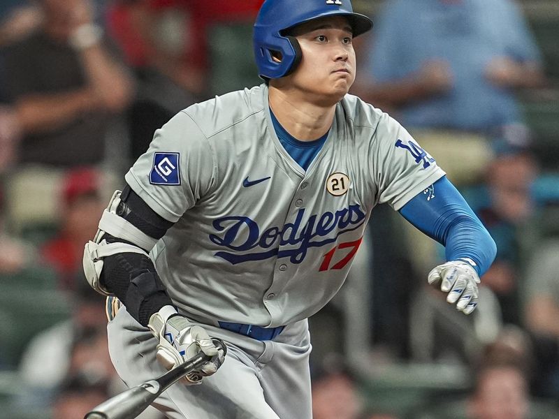 Sep 15, 2024; Cumberland, Georgia, USA; Los Angeles Dodgers designated hitter Shohei Ohtani (17) hits a double to drive in a run against the Atlanta Braves during the seventh inning at Truist Park. Mandatory Credit: Dale Zanine-Imagn Images