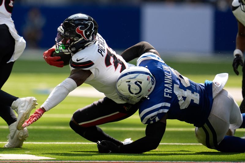 Houston Texans running back Dameon Pierce (31) is tackled by Indianapolis Colts linebacker Zaire Franklin (44) during the second half of an NFL football game, Sunday, Sept. 8, 2024, in Indianapolis. (AP Photo/Michael Conroy)