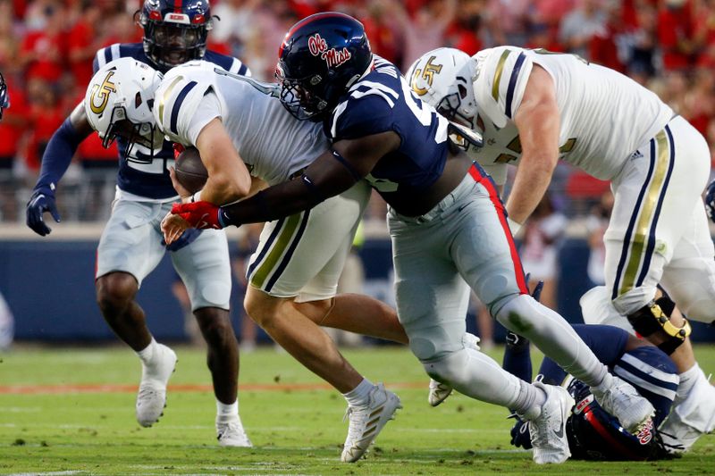 Sep 16, 2023; Oxford, Mississippi, USA; Mississippi Rebels defensive linemen Isaac Ukwu (99) tackles Georgia Tech Yellow Jackets quarterback Haynes King (10) during the first half at Vaught-Hemingway Stadium. Mandatory Credit: Petre Thomas-USA TODAY Sports